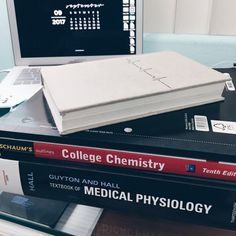 a stack of books sitting next to a laptop computer