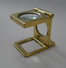 a magnifying glass sitting on top of a metal stand with a hole in the middle