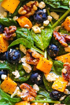 a salad with blueberries, spinach and walnuts