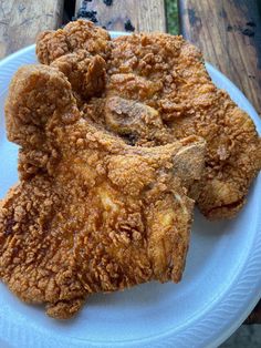 fried food on a white plate sitting on a wooden table