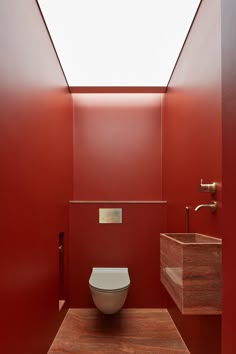 a white toilet sitting inside of a bathroom next to a wooden counter top under a skylight