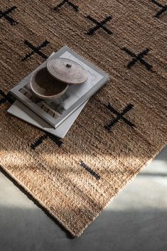 a brown rug with black crosses on it and a bowl sitting on top of it