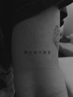 a black and white photo of a woman's thigh with the word divine written on it