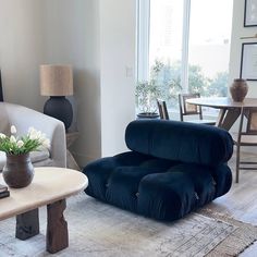 a living room filled with furniture next to a table and chairs in front of a window