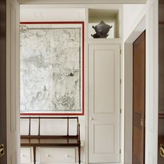 a room with a map on the wall and a bench in front of an open door