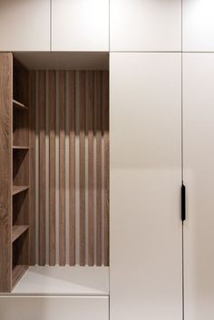 an empty closet with wooden slats on the doors and shelves in front of it