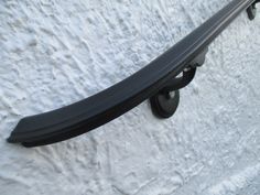 a skateboard mounted to the side of a white wall with black wheels on it