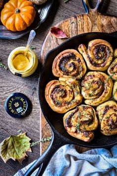 a pan filled with cinnamon rolls on top of a wooden table