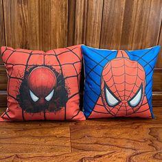 two spiderman pillows sitting on top of a wooden floor