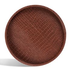 a brown leather plate with an alligator skin pattern on the bottom and sides, set against a white background