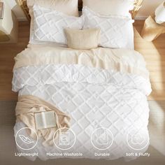 a bed with white comforters and pillows on it