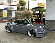 a grey car parked in front of a gas station