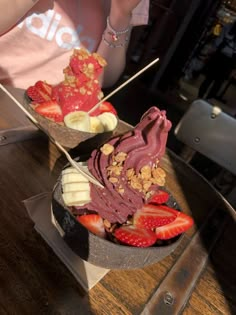 two bowls filled with different types of food on top of a wooden table next to each other