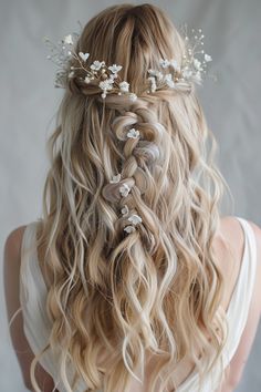 a woman with long blonde hair and flowers in her hair is shown from the back