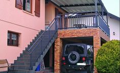 a car parked in front of a building with stairs leading up to the second story