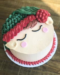 a cake decorated to look like a woman's face with braids on it