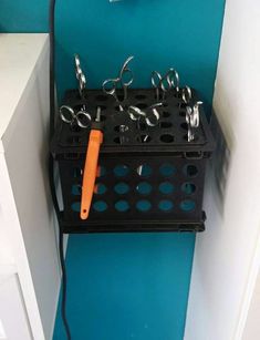 there are many pairs of scissors and pliers in the holder on the shelf next to the sink