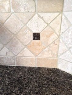 a kitchen counter top with a clock on the wall and tile backsplash above it