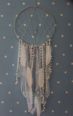 a dream catcher hanging on the wall in a room with polka dot walls and white dots