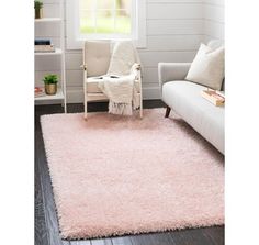 a living room with a white couch and pink rug