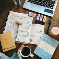 a person sitting at a desk with a laptop, notebook and coffee in front of them