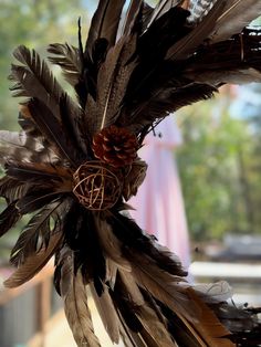 a close up of a bird's nest with feathers and pinecones on it