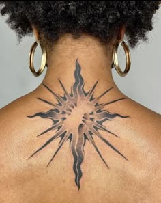 the back of a woman's neck with an intricate tattoo design on her upper back