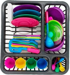 the tray is filled with colorful dishes and utensils for children to play in