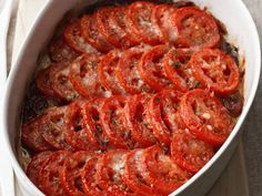 a casserole dish filled with sliced tomatoes