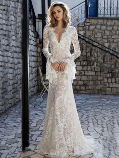 a woman in a white wedding dress standing on a brick floor next to a staircase