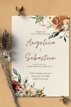 an elegant wedding card with flowers and greenery