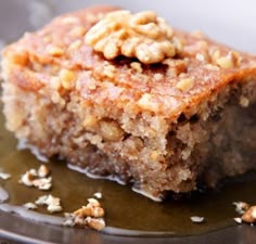 a piece of cake sitting on top of a plate covered in nuts and icing