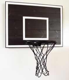 a basketball hoop mounted to the side of a white wall with black lines on it