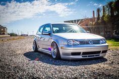 a silver car parked on top of a gravel road