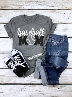 a t - shirt that says wrestling mom on the front, jeans and sneakers are next to it