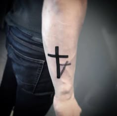 a person with a cross tattoo on their arm