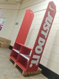 a red sign that is sitting in the middle of a room with cardboard boxes around it