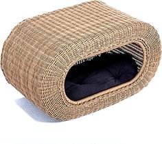 a cat bed made out of wicker with a black pillow on the top and bottom