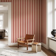 a chair and ottoman in front of a striped wall