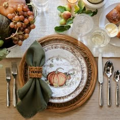 a table set with plates, silverware and napkins for thanksgiving dinner or brunch