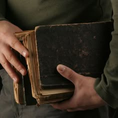 a person holding an old book in their hands