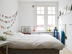 a bed sitting in a bedroom next to a window