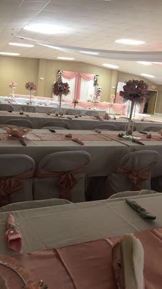 rows of chairs with pink sashes and bows are set up for a wedding reception