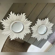 two circular mirrors mounted to the side of a wooden ceiling above a wicker basket