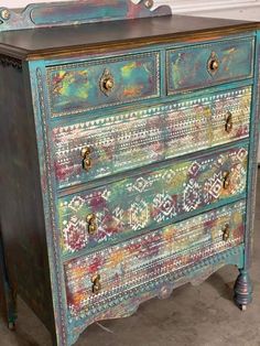 an old dresser painted with multicolored paint