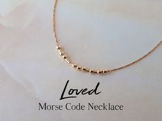 "This delicate gold filled necklace spells the word \"Loved\" in Morse code, as a secret reminder of a loving bond. A meaningful piece of jewelry that will make a delightful gift for any of your loved ones! The word \"Loved\" is spelled in Morse code using round gold filled beads representing the dots, and gold filed tubes as the dashes. The necklace will come with a card displaying the message in both Morse code and English. ABOUT THE MATERIALS: - The gold filled round beads measure 3mm, so thi Secret Message Jewelry, Morse Code Words, Code Morse, Morse Code Necklace, Mantra Bracelet, Message Necklace, Memorial Bracelet, Hidden Message, Morse Code Bracelet