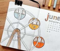 a spiral notebook with an image of a ferris wheel and the words june written on it