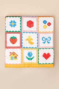 a quilted wall hanging on the side of a wall with different designs and colors