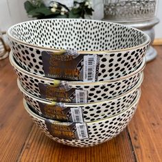 four white and black polka dot bowls stacked on top of each other