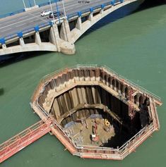 an aerial view of a bridge over water with a boat in the middle and another one on the other side